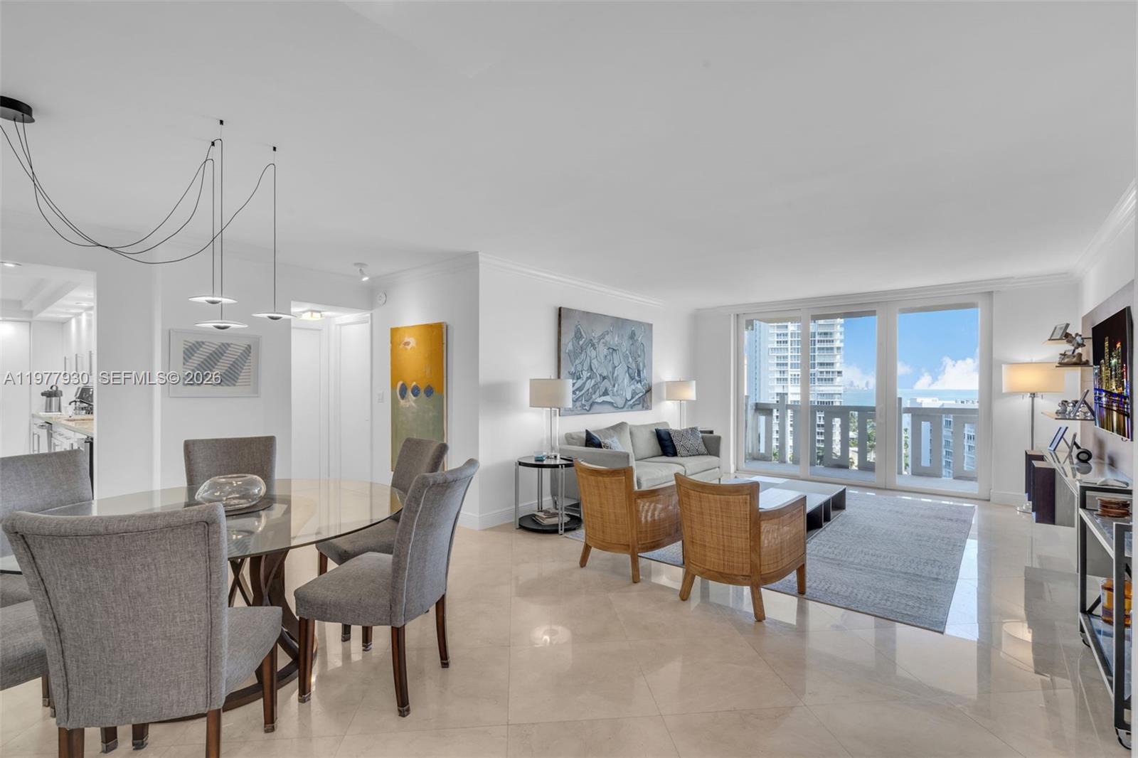 A bright open-concept living and dining area features tile floors, modern furniture, and balcony views — 1121 Crandon Blvd # E1203, Key Biscayne FL 33149, KEY BISCAYNE, FL