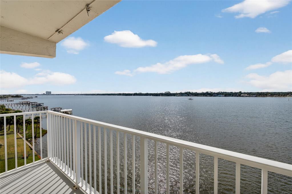 A balcony with a white railing overlooks a wide body of water under a blue sky — 2711 N HALIFAX AVENUE UNIT 695, DAYTONA BEACH, FL