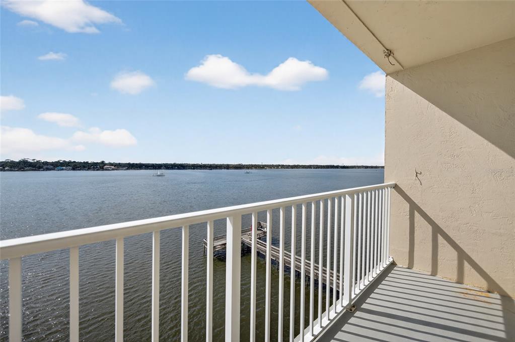 A balcony with a white railing overlooks a large body of water and a pier — 2711 N HALIFAX AVENUE UNIT 695, DAYTONA BEACH, FL