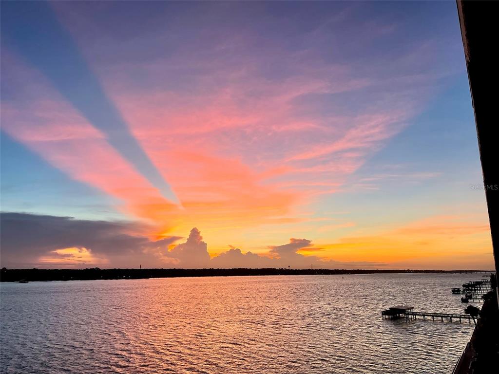 A sunset view over a wide body of water with a wooden pier — 2711 N HALIFAX AVENUE UNIT 695, DAYTONA BEACH, FL