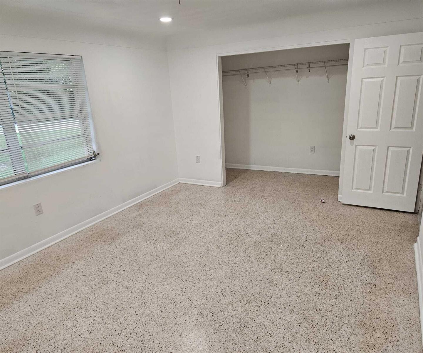 An empty bedroom features white walls, a window with blinds, beige carpet, and a closet — 1980 Kirk Road, West Palm Beach FL 33406, WEST PALM BEACH, FL