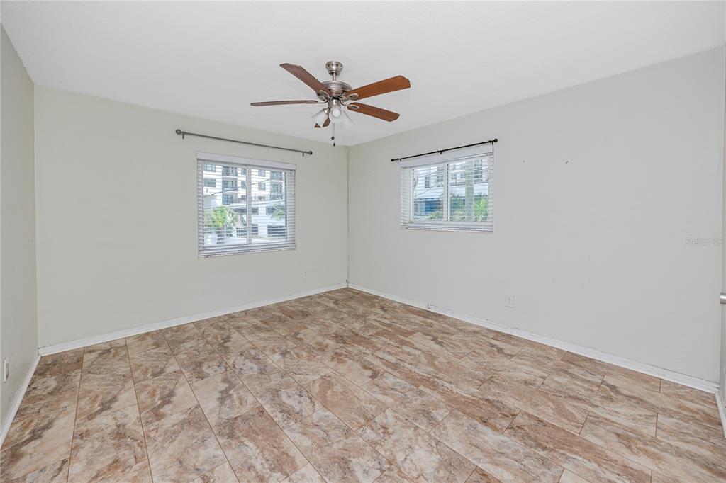 An empty bedroom features light green walls, a ceiling fan, and brown tiled flooring — 4340 37TH STREET S UNIT 6, ST PETERSBURG, FL