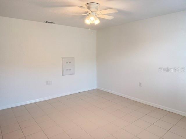 An empty room features white walls, a ceiling fan, and light-colored square floor tiles — 5100 PROVIDENCE CIRCLE UNIT 3, NEW PORT RICHEY, FL