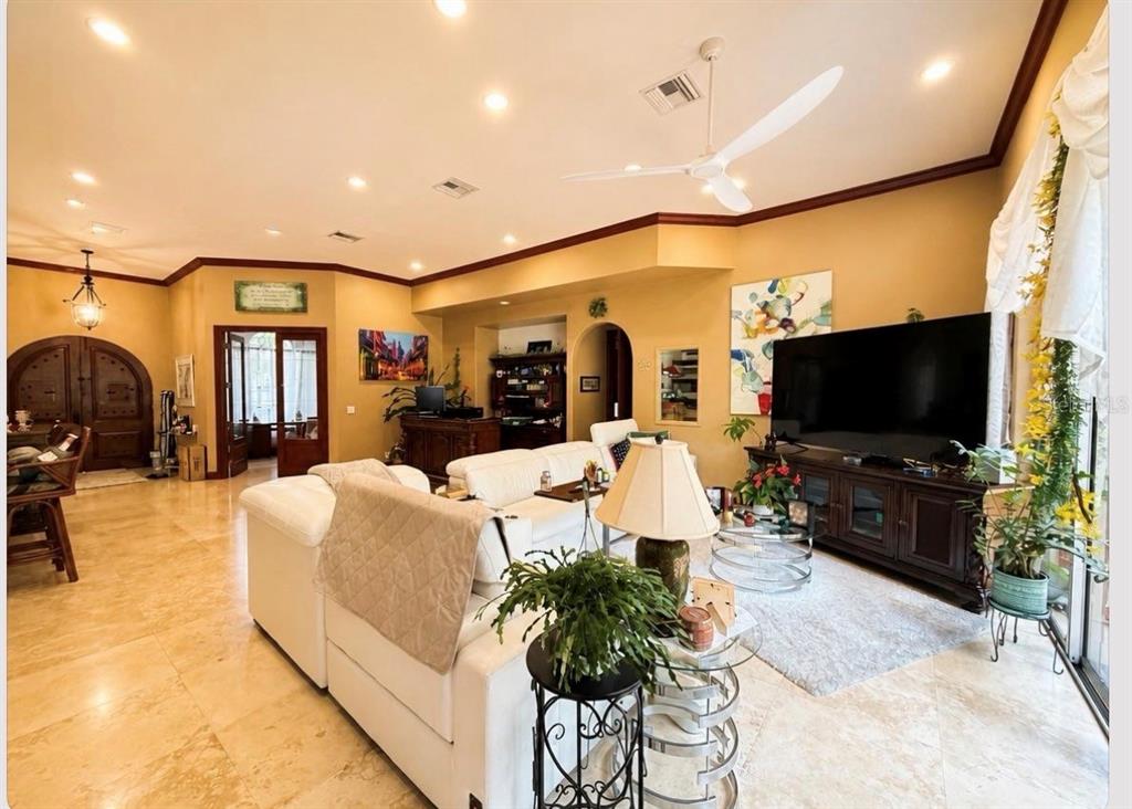 A spacious living room features tile flooring, a wooden bar, and a large white sectional — 4205 CREMONA COURT, SEBRING, FL