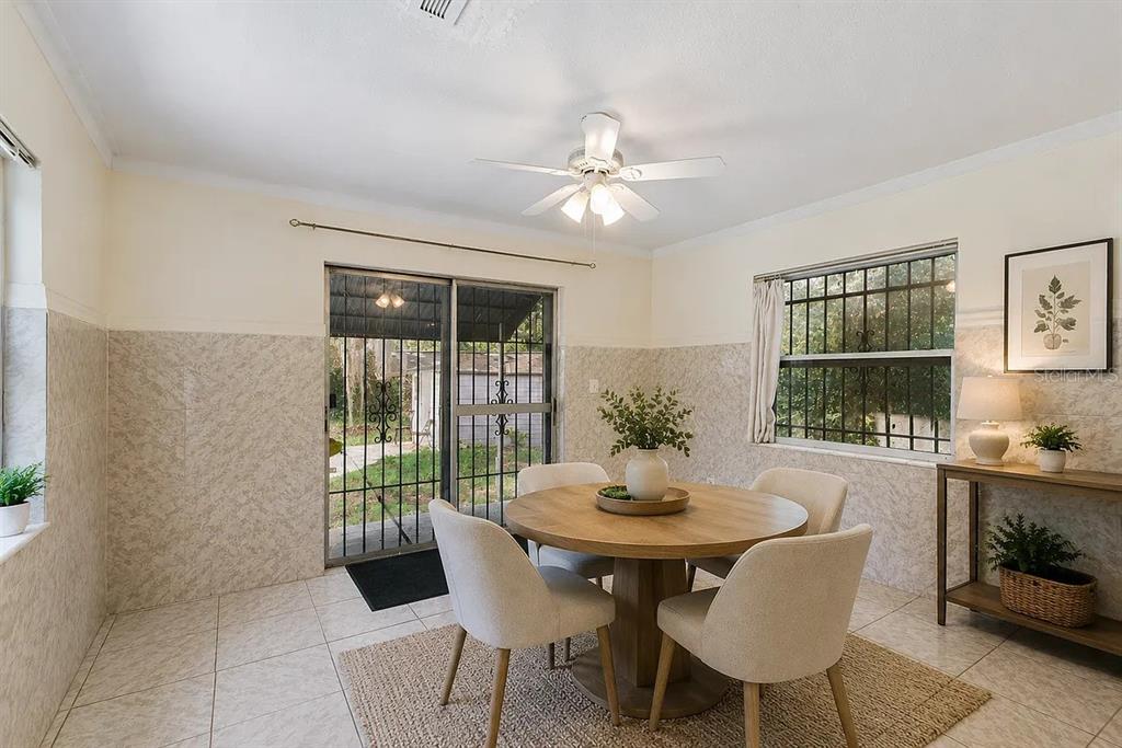 A dining room with tile flooring, a round wooden table, and sliding glass doors — 1227 MERRITT STREET, ALTAMONTE SPRINGS, FL