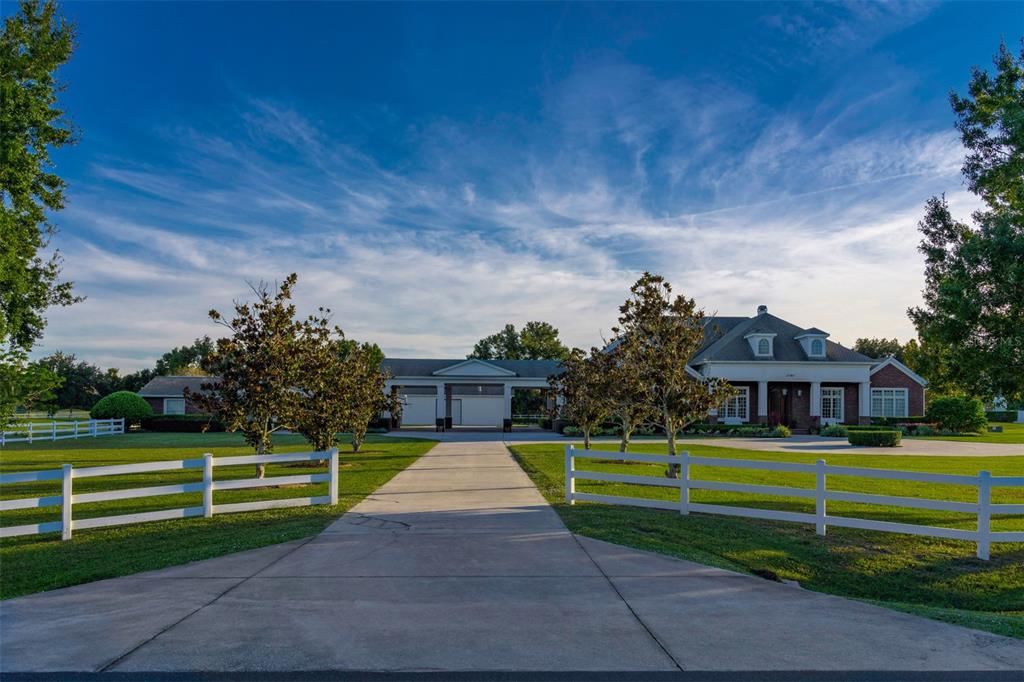 A long concrete driveway leads to a large house with a detached garage and fence — 2780 VICKIE COURT, KISSIMMEE, FL
