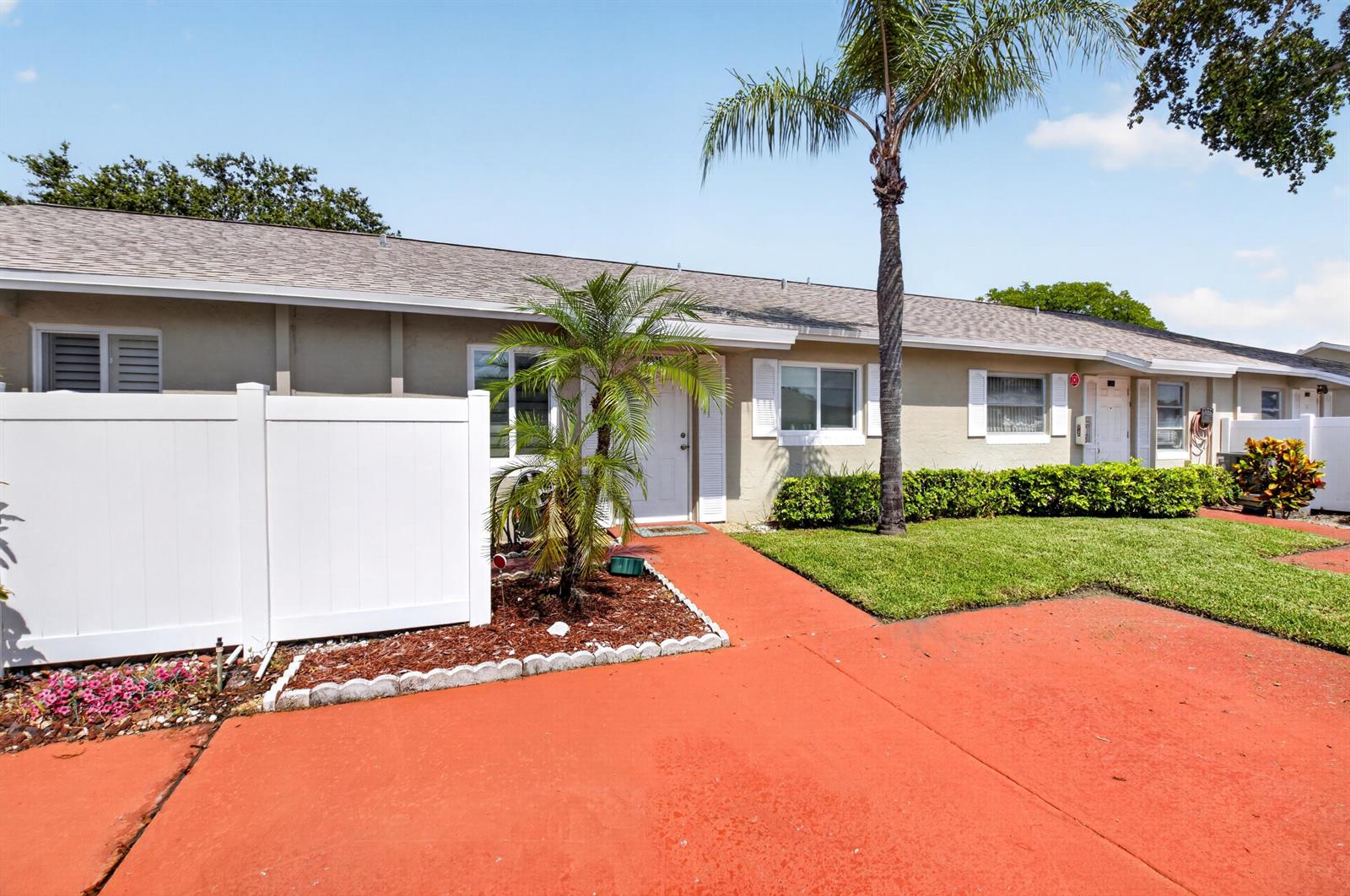 A single-story residential building with a red driveway, white fence, and a palm tree — 18925 Argosy Drive # B, Boca Raton FL 33496, BOCA RATON, FL