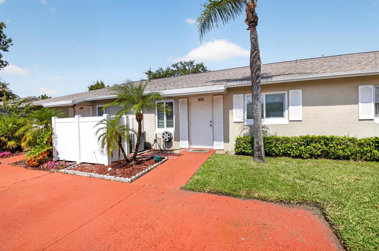 A single-story residential unit features a white front door, shutters, and a palm tree — 18925 Argosy Drive # B, Boca Raton FL 33496, BOCA RATON, FL
