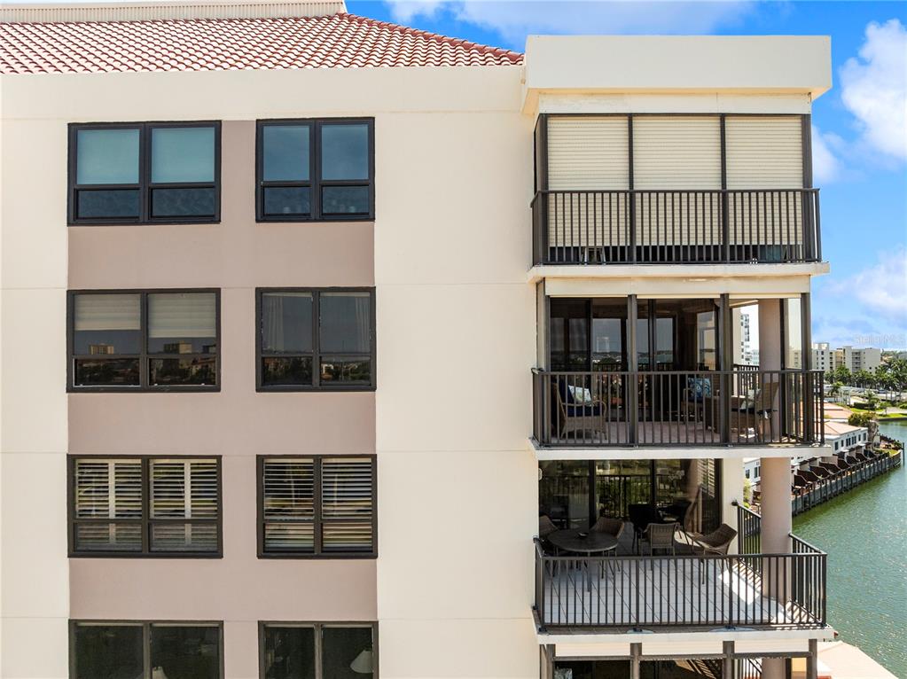 An exterior view of a multi-story building featuring balconies and windows overlooking a canal — 6294 BAHIA DEL MAR CIRCLE UNIT 904, ST PETERSBURG, FL