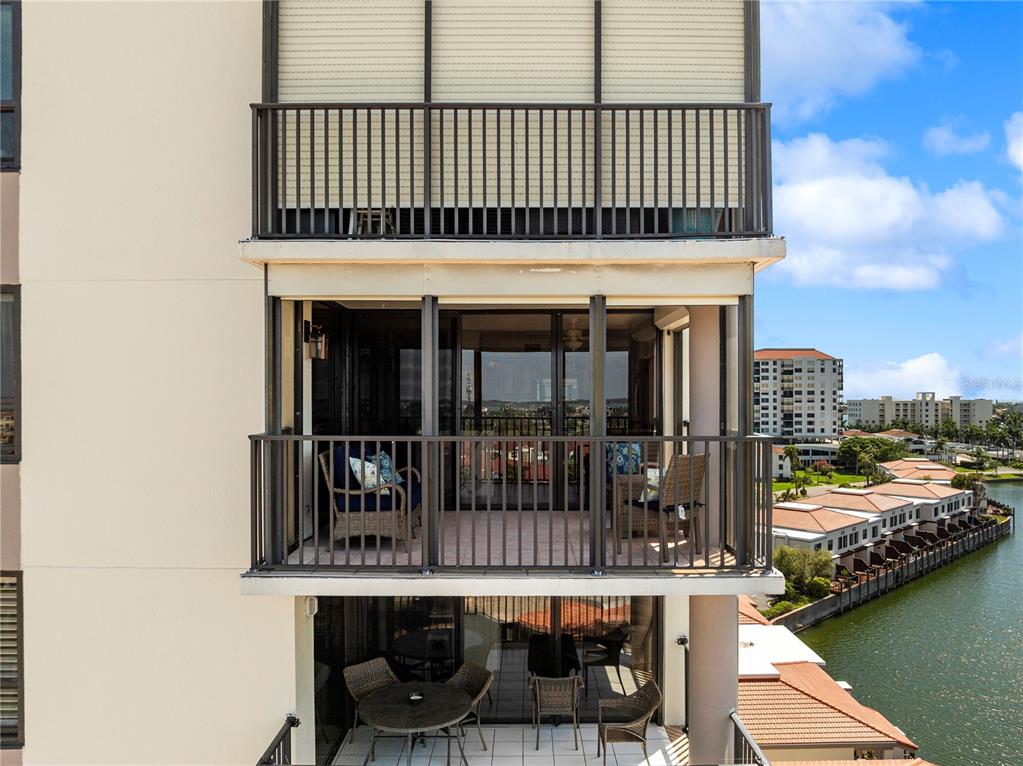 An exterior view of two stacked balconies overlooking a canal and residential buildings — 6294 BAHIA DEL MAR CIRCLE UNIT 904, ST PETERSBURG, FL