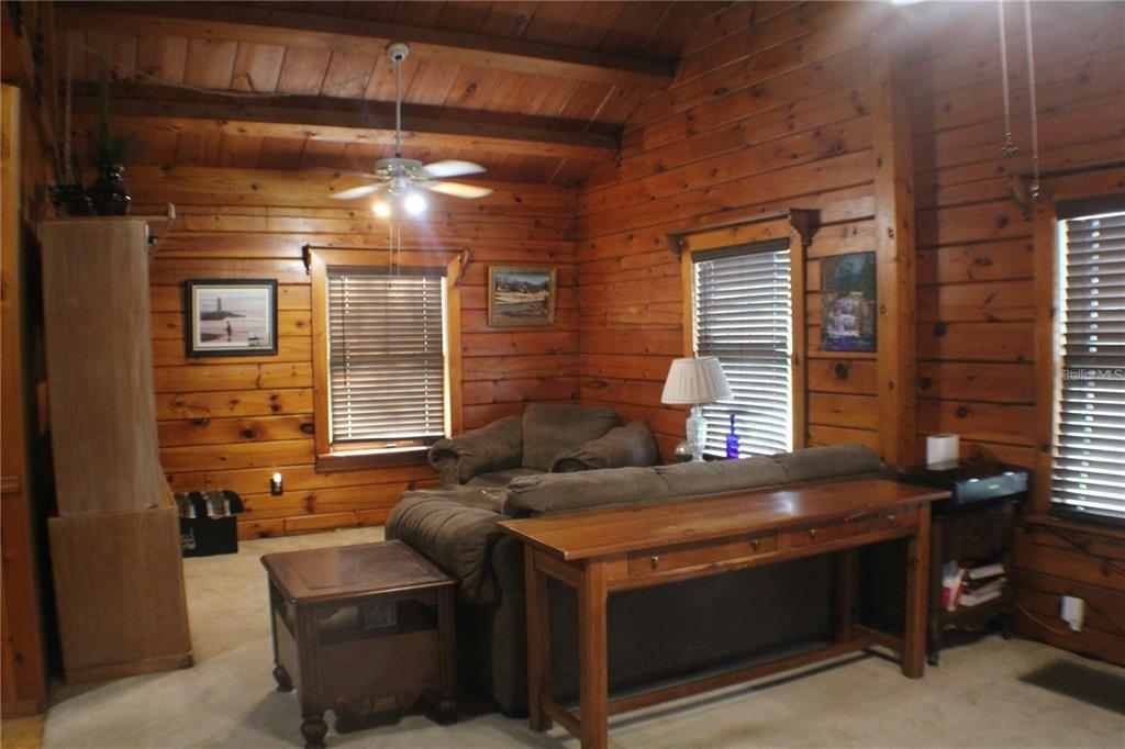 A living room features wood-paneled walls, a brown sofa, and a wooden console table — 3045 YORKSHIRE DRIVE, DELTONA, FL