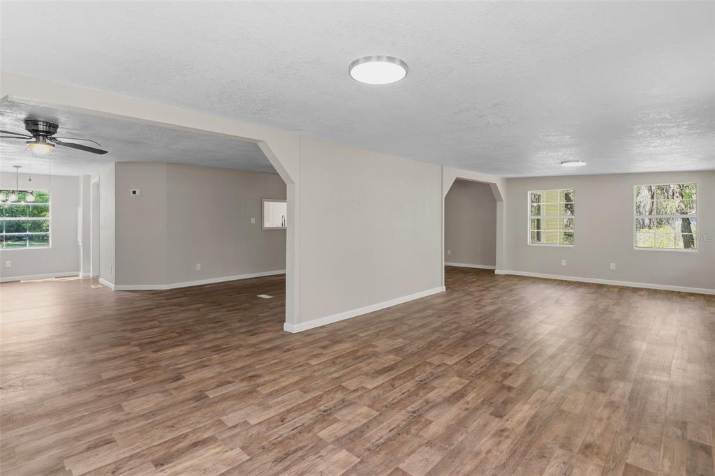 An open-concept living area features light gray walls, wood-look flooring, and recessed ceiling lighting — 6111 KLARE DRIVE, KEYSTONE HEIGHTS, FL