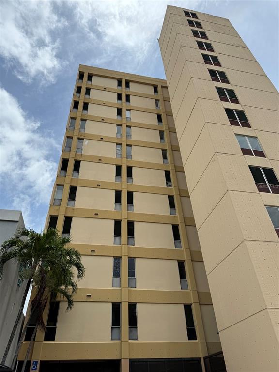 A low-angle exterior view of a tall, beige, multi-story apartment building with many windows — 414 MUÑOZ RIVERA AVENUE UNIT 6A & 6B, SAN JUAN, PR