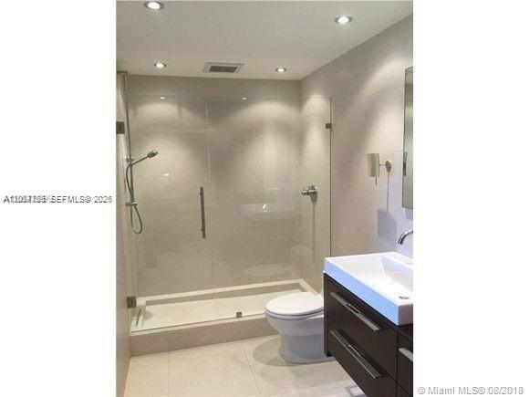 A modern bathroom features a glass-enclosed walk-in shower, a white toilet, and a dark vanity — 14340 SW 57th Ln # 204, Miami FL 33183, MIAMI, FL