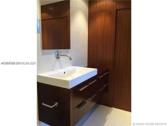 A modern bathroom features a white rectangular sink on a dark wood floating vanity — 14340 SW 57th Ln # 204, Miami FL 33183, MIAMI, FL