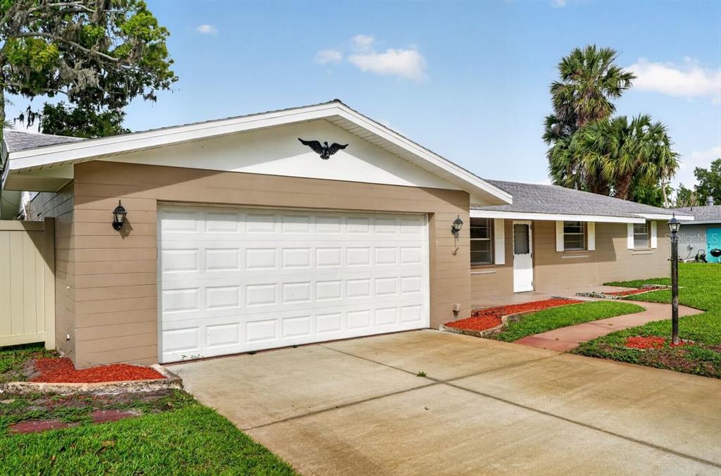 A single-story house with a tan exterior, white garage door, and a concrete driveway — 2342 CITRUS AVENUE, SOUTH DAYTONA, FL