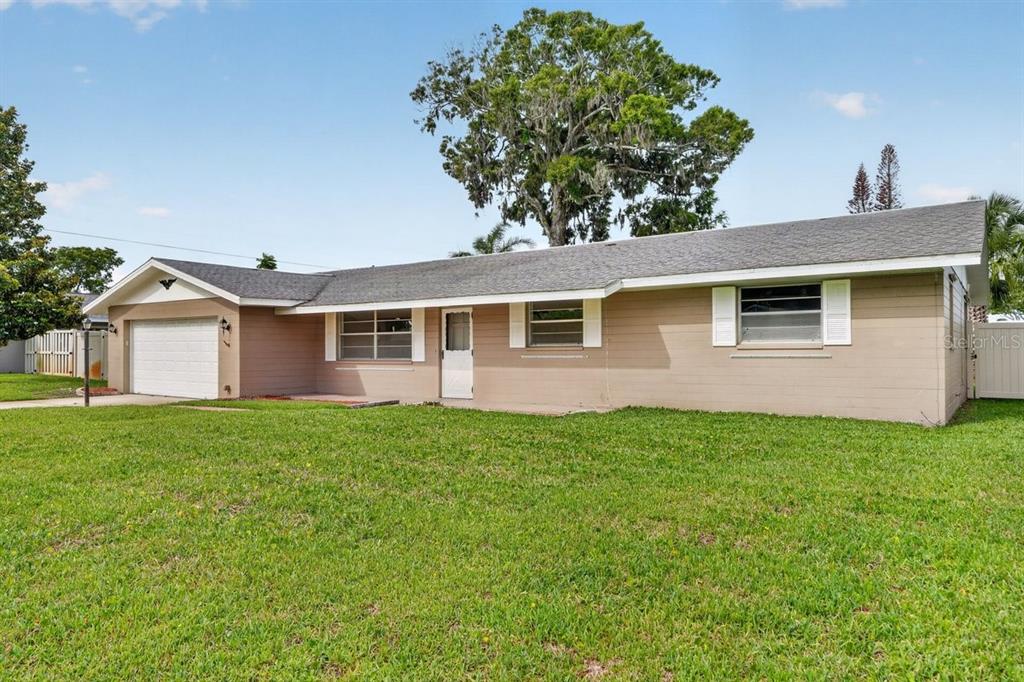 A single-story tan house with a white garage door and a large front lawn — 2342 CITRUS AVENUE, SOUTH DAYTONA, FL