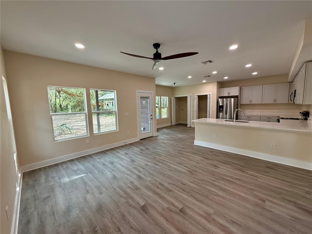 An open-concept living room and kitchen featuring light wood-look flooring and recessed lighting — 4409 NW 31ST AVENUE, GAINESVILLE, FL