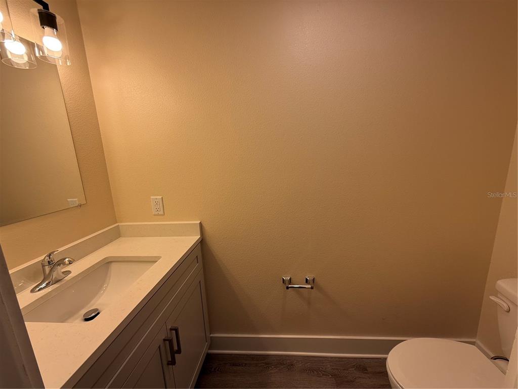 A bathroom features a vanity with a white countertop, a mirror, and a toilet — 4409 NW 31ST AVENUE, GAINESVILLE, FL