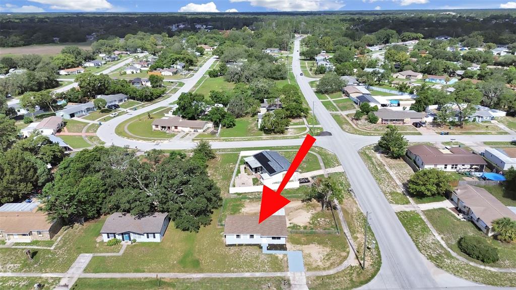 An aerial view shows a single-story house with a brown roof on a corner lot — 9667 BAYSIDE COURT, SPRING HILL, FL