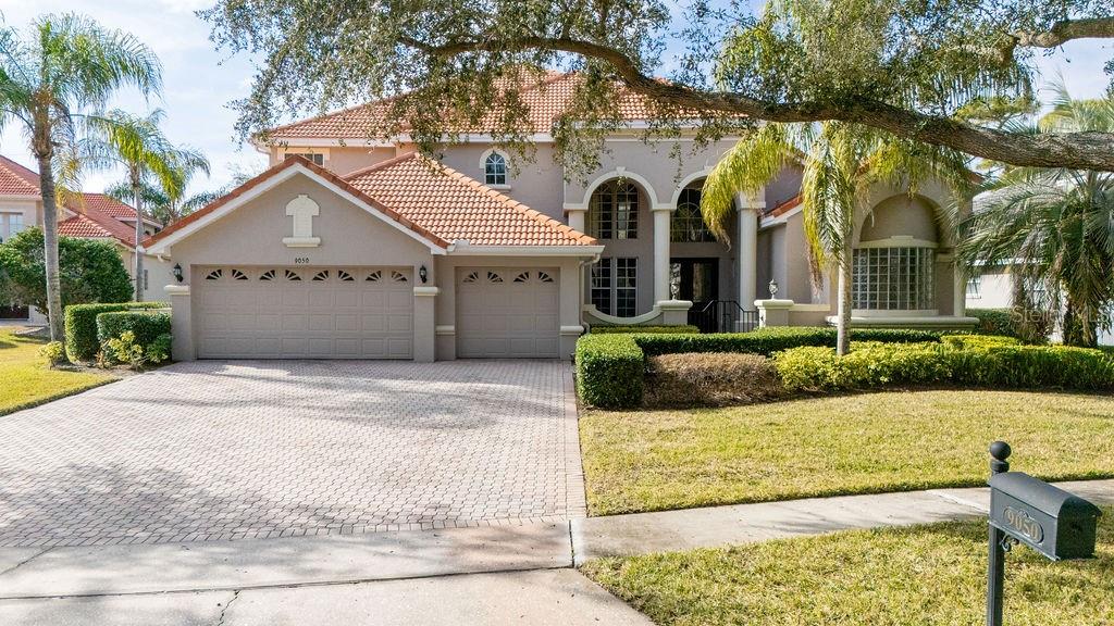 A two-story house with a tile roof, two-car garage, and a paved driveway — 9050 DANCY TREE COURT, ORLANDO, FL