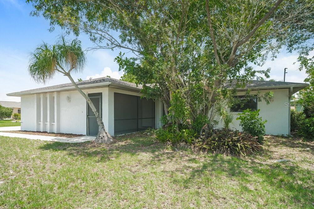 A single-story house with a screened-in porch and a large tree in the front yard — 1329 SE 12TH STREET, CAPE CORAL, FL