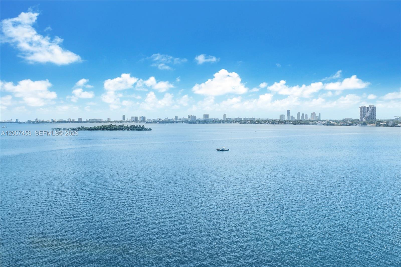 A wide-angle view shows a calm bay with a small boat and distant city skyline — 725 NE 22nd St # 7B, Miami FL 33137, MIAMI, FL
