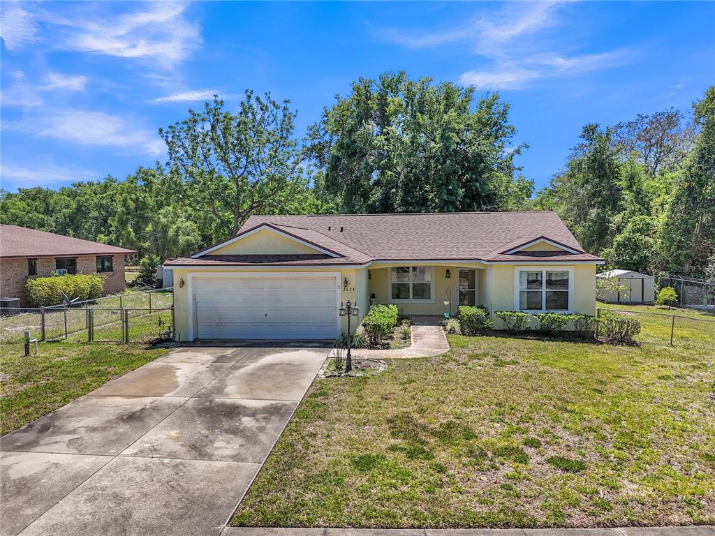 A yellow single-story house with a two-car garage and a concrete driveway — 3624 TROUT AVENUE, FRUITLAND PARK, FL