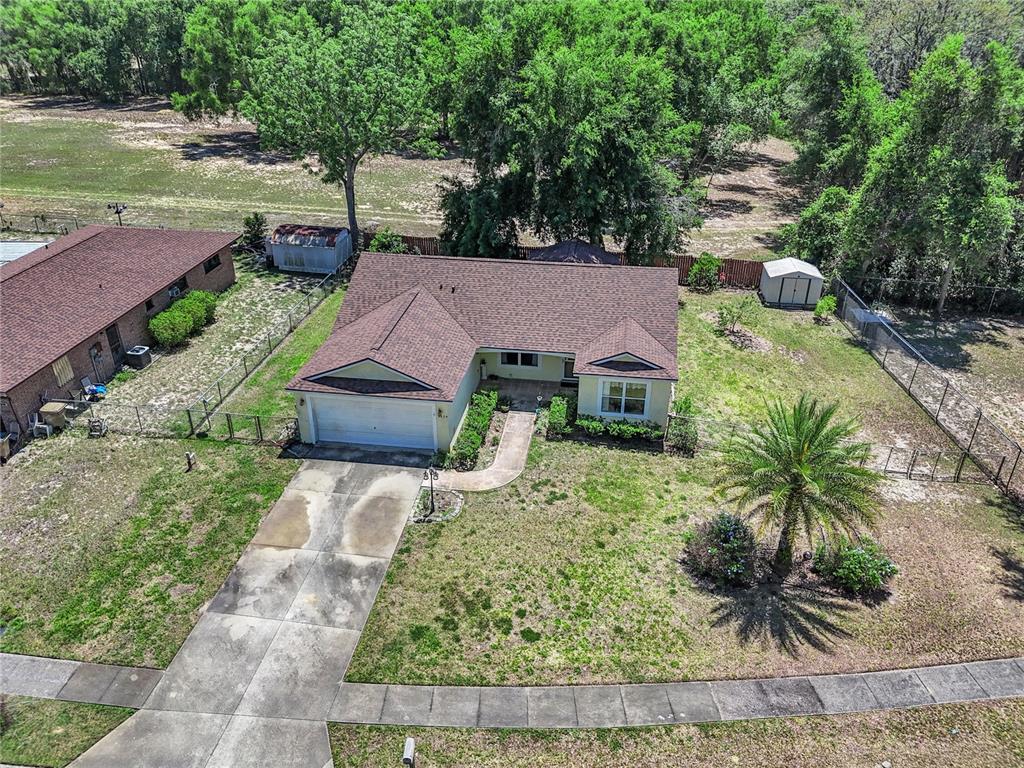 An aerial view shows a single-story house with a driveway, lawn, and two storage sheds — 3624 TROUT AVENUE, FRUITLAND PARK, FL