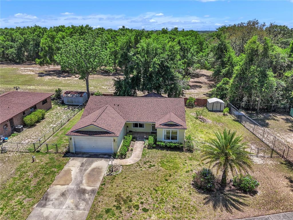 An aerial view of a single-story house with a garage, driveway, and fenced backyard — 3624 TROUT AVENUE, FRUITLAND PARK, FL