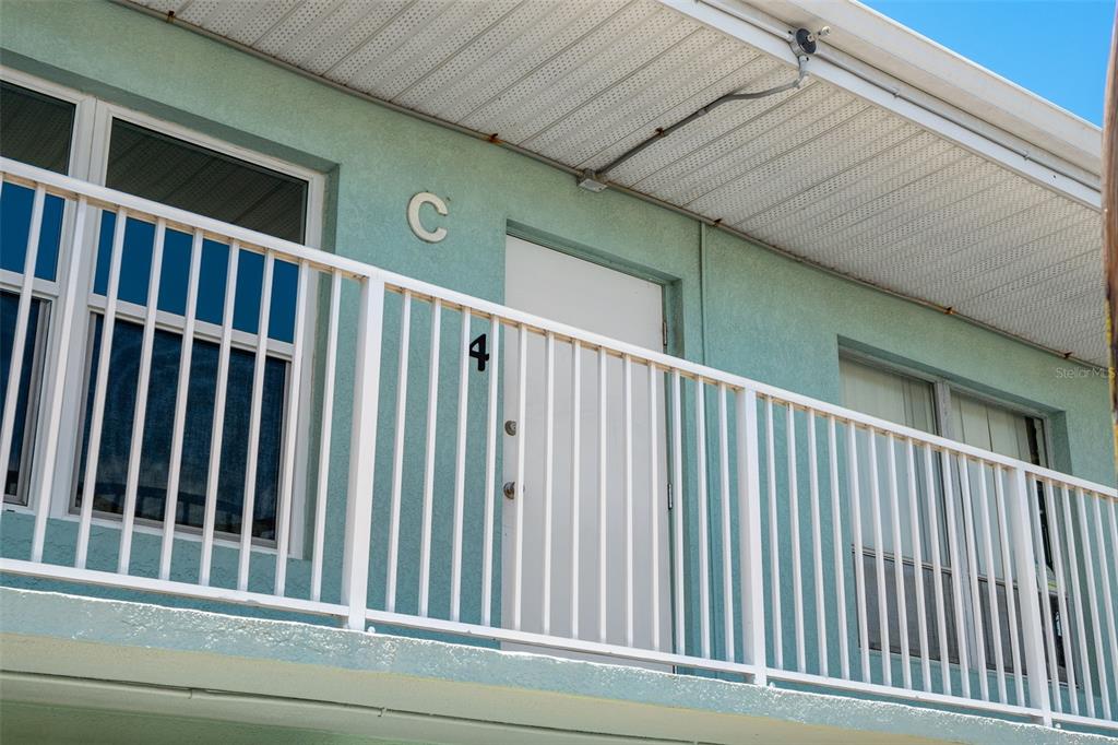 A teal exterior wall features a white door labeled number four under a white railing — 420 TYLER AVENUE UNIT 4-3, CAPE CANAVERAL, FL