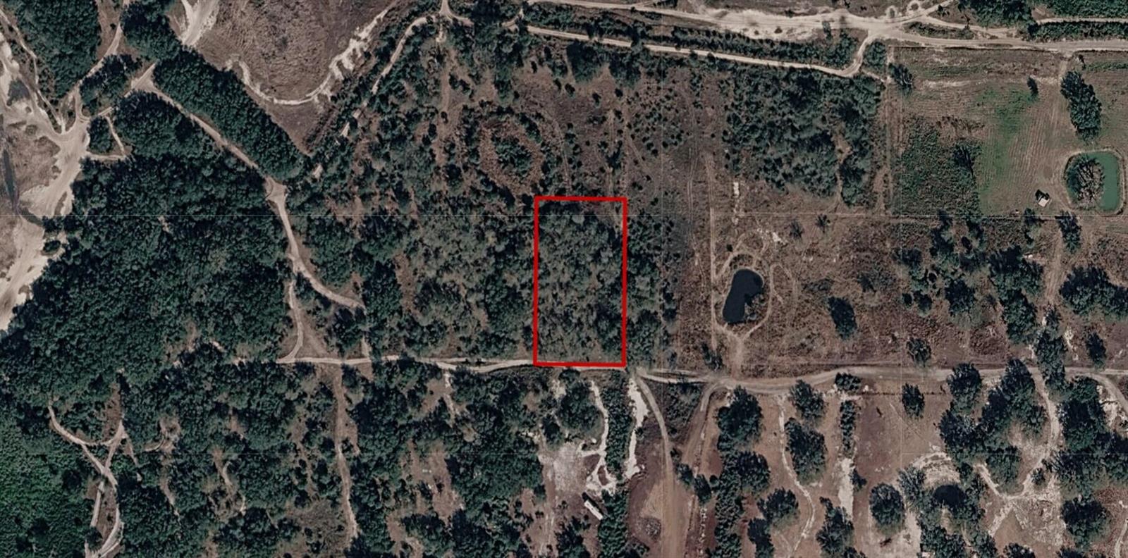 An aerial view shows a rectangular plot of land outlined in red amidst wooded terrain — 0 NW 300th Street, Okeechobee FL 34972, OKEECHOBEE, FL