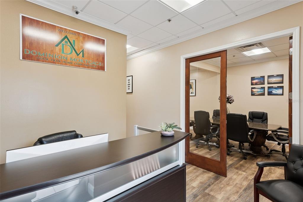 An office reception area features a dark wood desk, a glass-paneled door, and a conference room — 3239 OLD WINTER GARDEN ROAD UNIT 9A & 9B, ORLANDO, FL