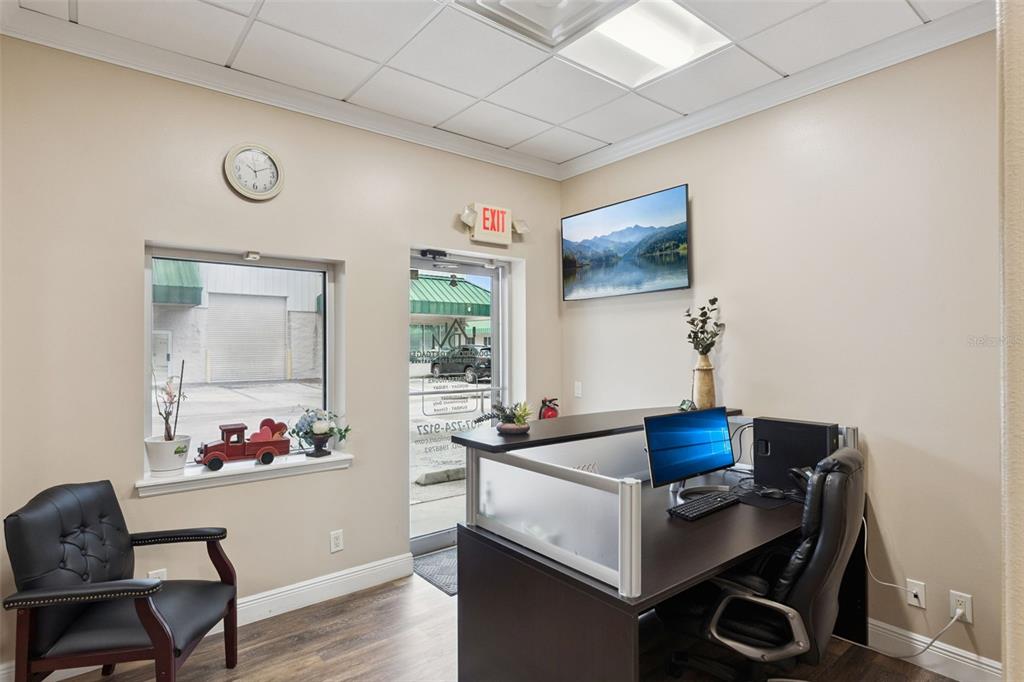 A small office space features a desk, a black chair, a window, and an exit door — 3239 OLD WINTER GARDEN ROAD UNIT 9A & 9B, ORLANDO, FL