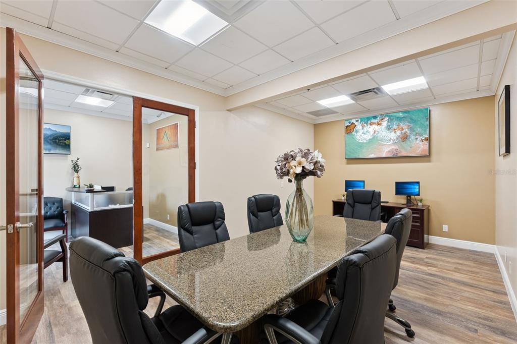 A conference room features a granite table, black leather chairs, and a large ocean wall art — 3239 OLD WINTER GARDEN ROAD UNIT 9A & 9B, ORLANDO, FL