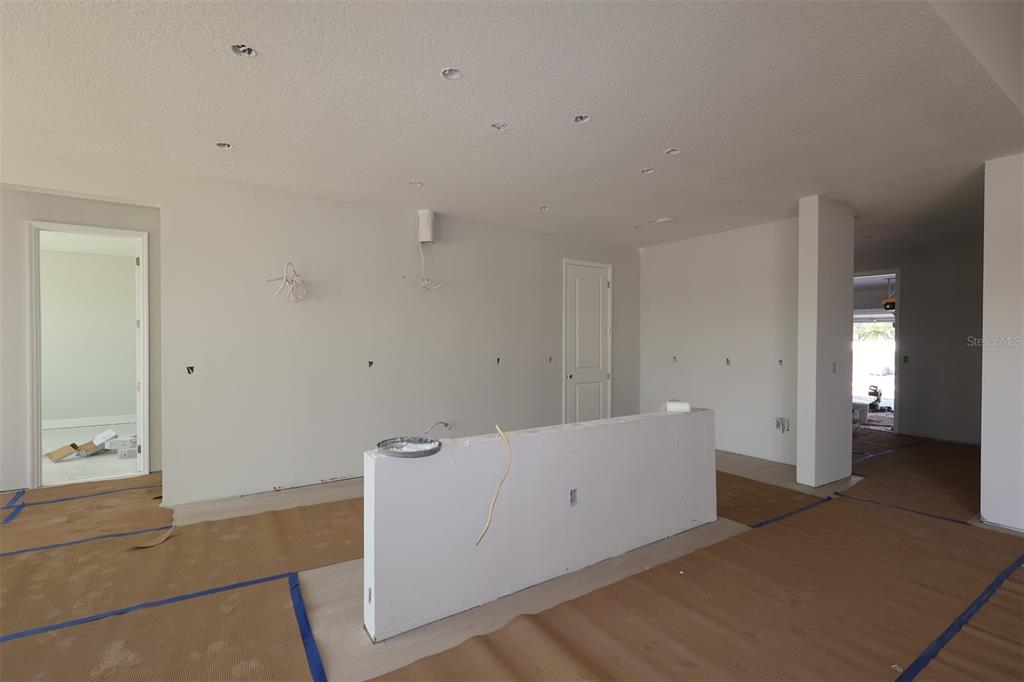 An unfinished interior space features white walls, recessed lighting, and protective paper on the floor — 17036 OVERSTORY ROAD, ORLANDO, FL