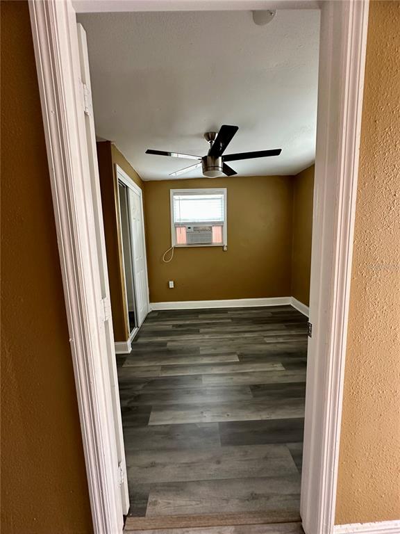 A bedroom with wood-look flooring, a ceiling fan, and a window air conditioning unit — 2907 N 15TH STREET UNIT D, TAMPA, FL