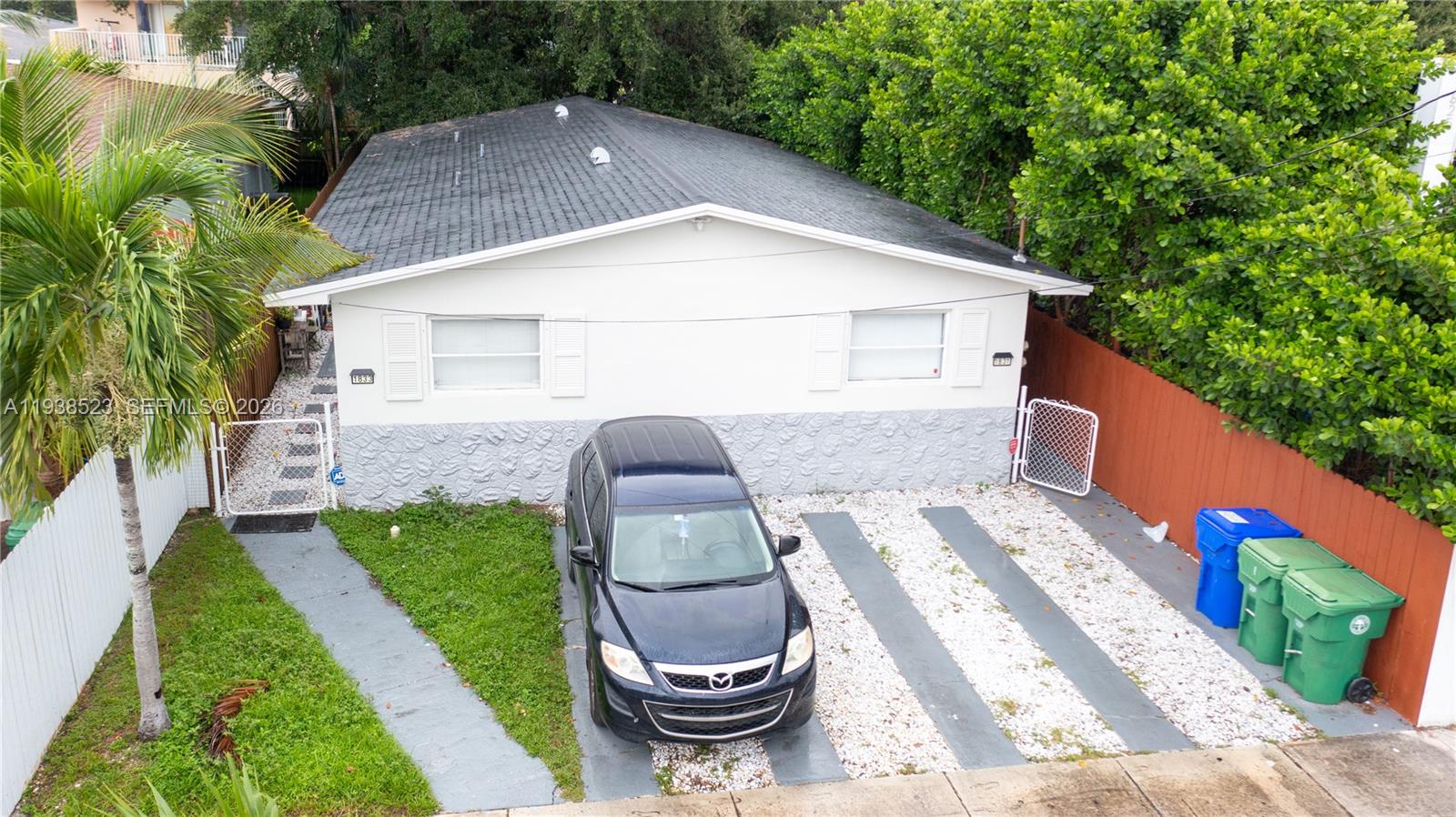 An aerial view of a single-story house with a gravel driveway and a parked car — 1831 NW 41 st, Miami FL 33142, MIAMI, FL