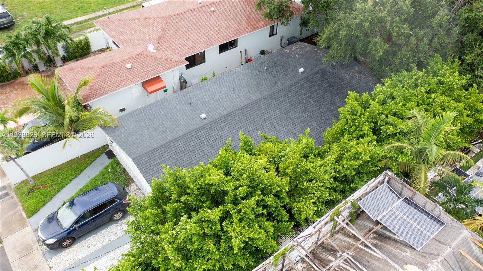 An aerial view shows a house with a gray shingled roof next to a neighboring property — 1831 NW 41 st, Miami FL 33142, MIAMI, FL