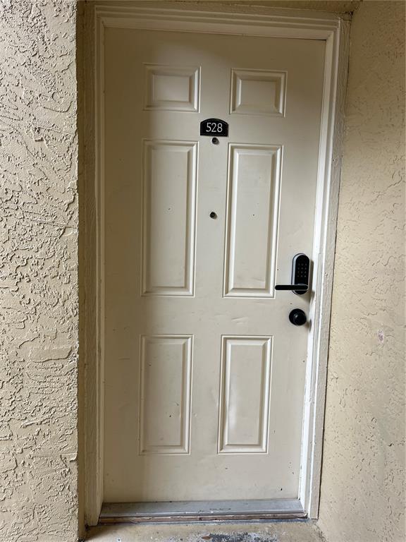 A beige apartment door with a digital keypad lock and the number 528 — 528 GOLDEN RAINTREE PLACE, BRANDON, FL