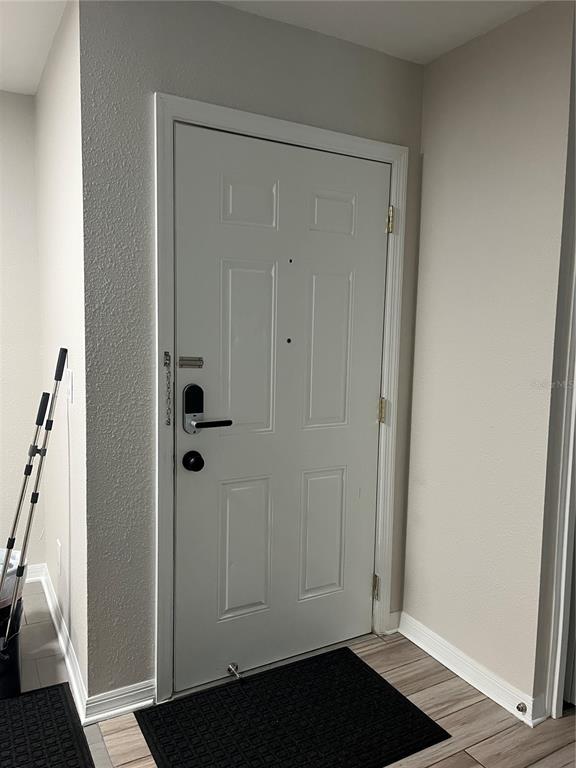A white front door with a smart lock and a black floor mat inside — 528 GOLDEN RAINTREE PLACE, BRANDON, FL