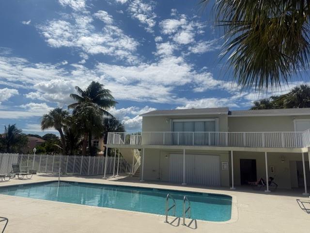 A rectangular swimming pool sits in front of a two-story building with a white balcony — 795 Crystal Lake Drive # 795, Deerfield Beach FL 33064, DEERFIELD BEACH, FL