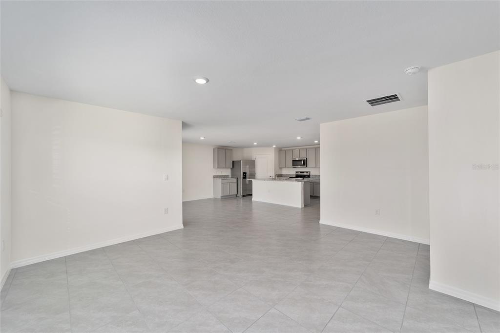 An open-concept living area features light gray tile flooring and a kitchen with gray cabinets — 8856 SW 49TH CIRCLE, OCALA, FL