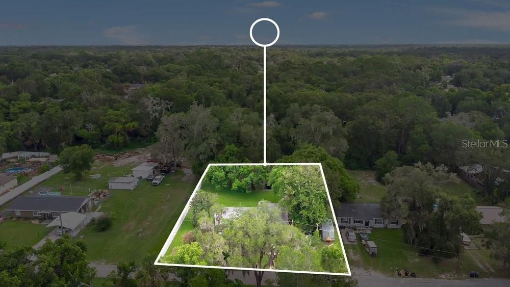 An aerial view shows a residential property with a house surrounded by trees and grass — 851 E UNIVERSITY AVENUE, ORANGE CITY, FL