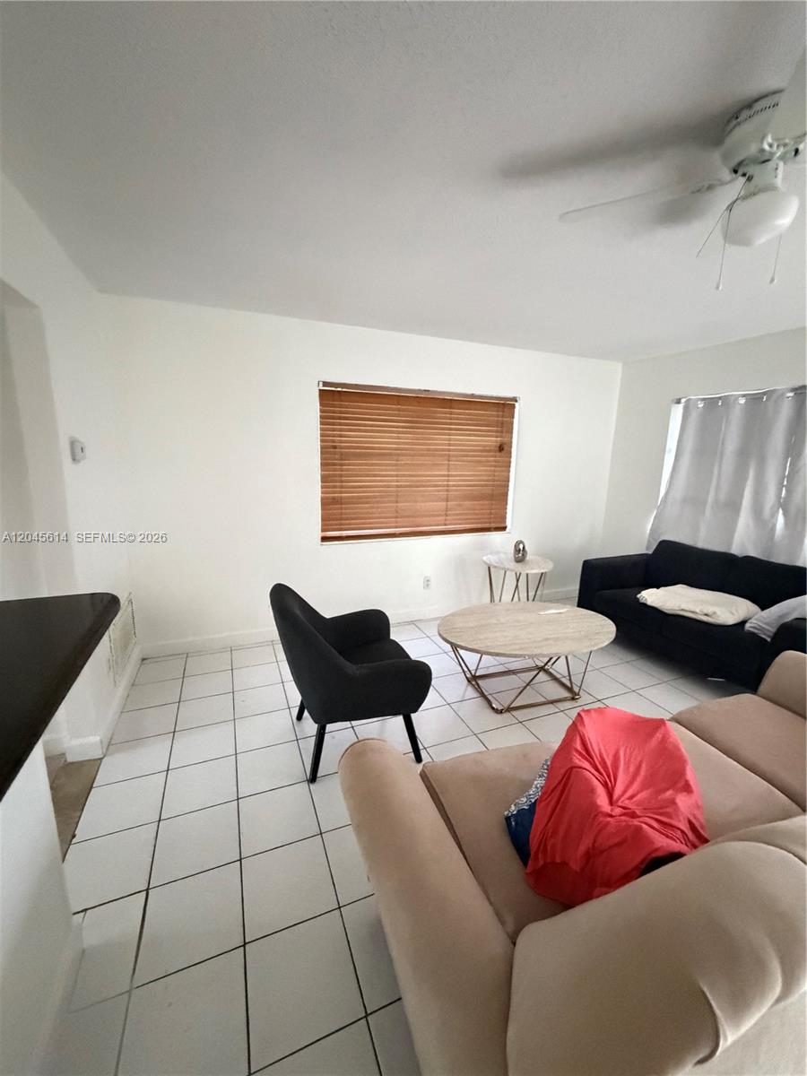 This living room features white tile flooring, a ceiling fan, and various seating furniture — 1170 NW 66th Ter, Margate FL 33063, MARGATE, FL