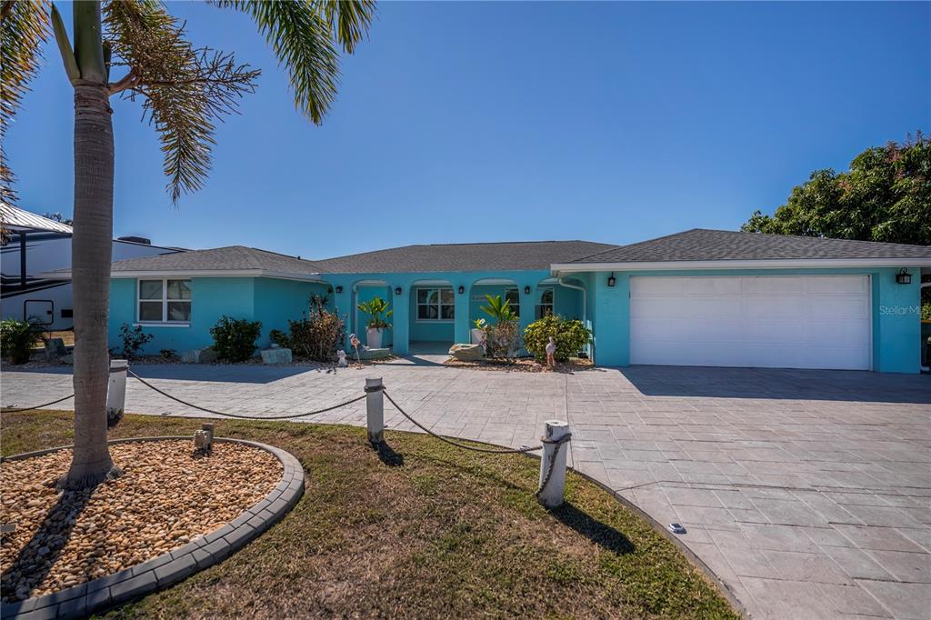 A single-story turquoise house with a paved driveway and a two-car garage — 121 SINCLAIR STREET SE, PORT CHARLOTTE, FL