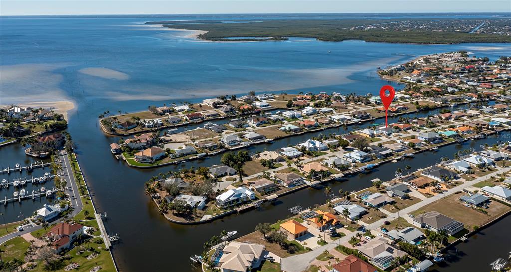An aerial view shows a waterfront residential neighborhood with canals and a red location pin — 121 SINCLAIR STREET SE, PORT CHARLOTTE, FL
