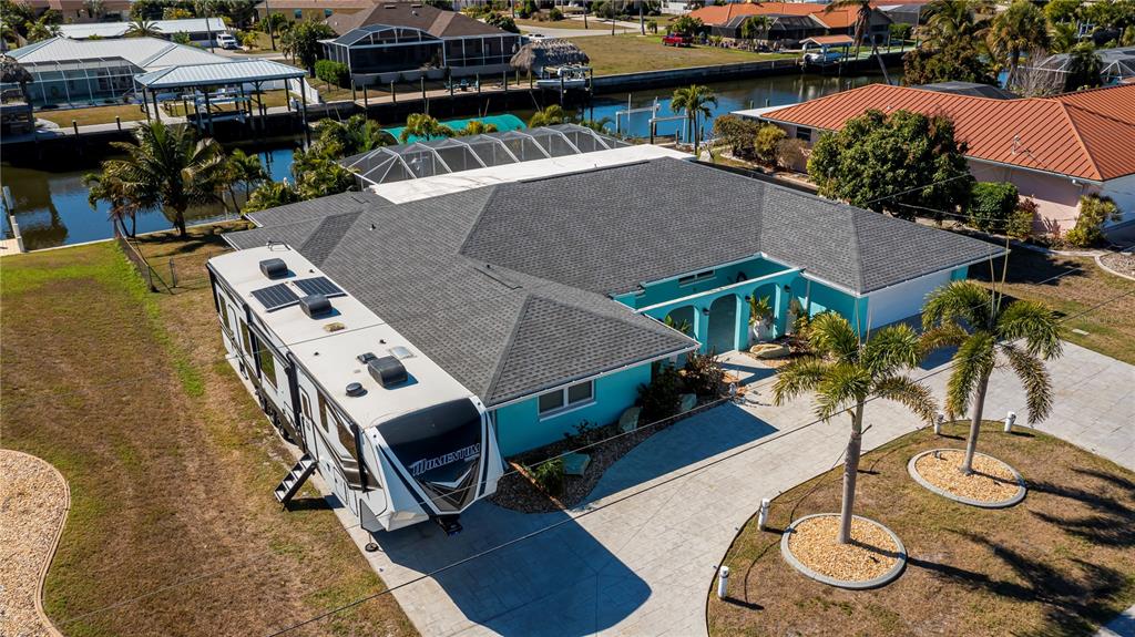 An aerial view of a teal house with a large RV parked in the driveway — 121 SINCLAIR STREET SE, PORT CHARLOTTE, FL