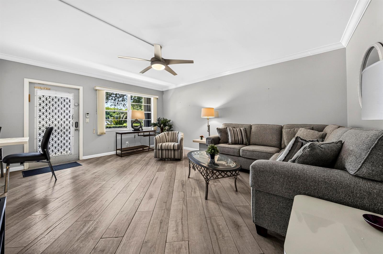 A living room features gray walls, wood-look flooring, a sectional sofa, and a ceiling fan — 1039 Berkshire B # 1039, Deerfield Beach FL 33442, DEERFIELD BEACH, FL