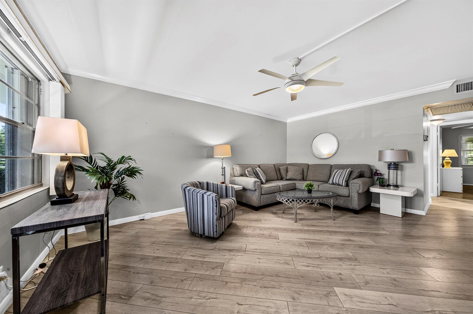 A living room features gray walls, wood-look flooring, a sectional sofa, and a ceiling fan — 1039 Berkshire B # 1039, Deerfield Beach FL 33442, DEERFIELD BEACH, FL